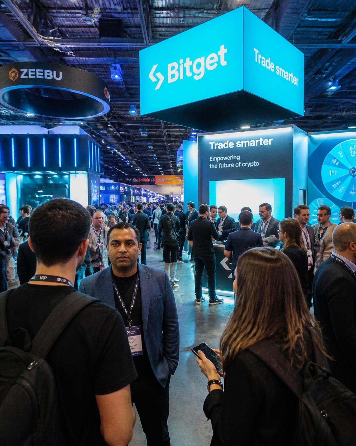 Attendees networking on a busy crypto expo floor between exhibitor booths